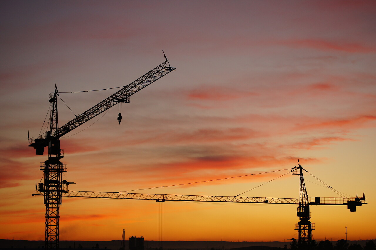 傍晚下的两个建筑起重机