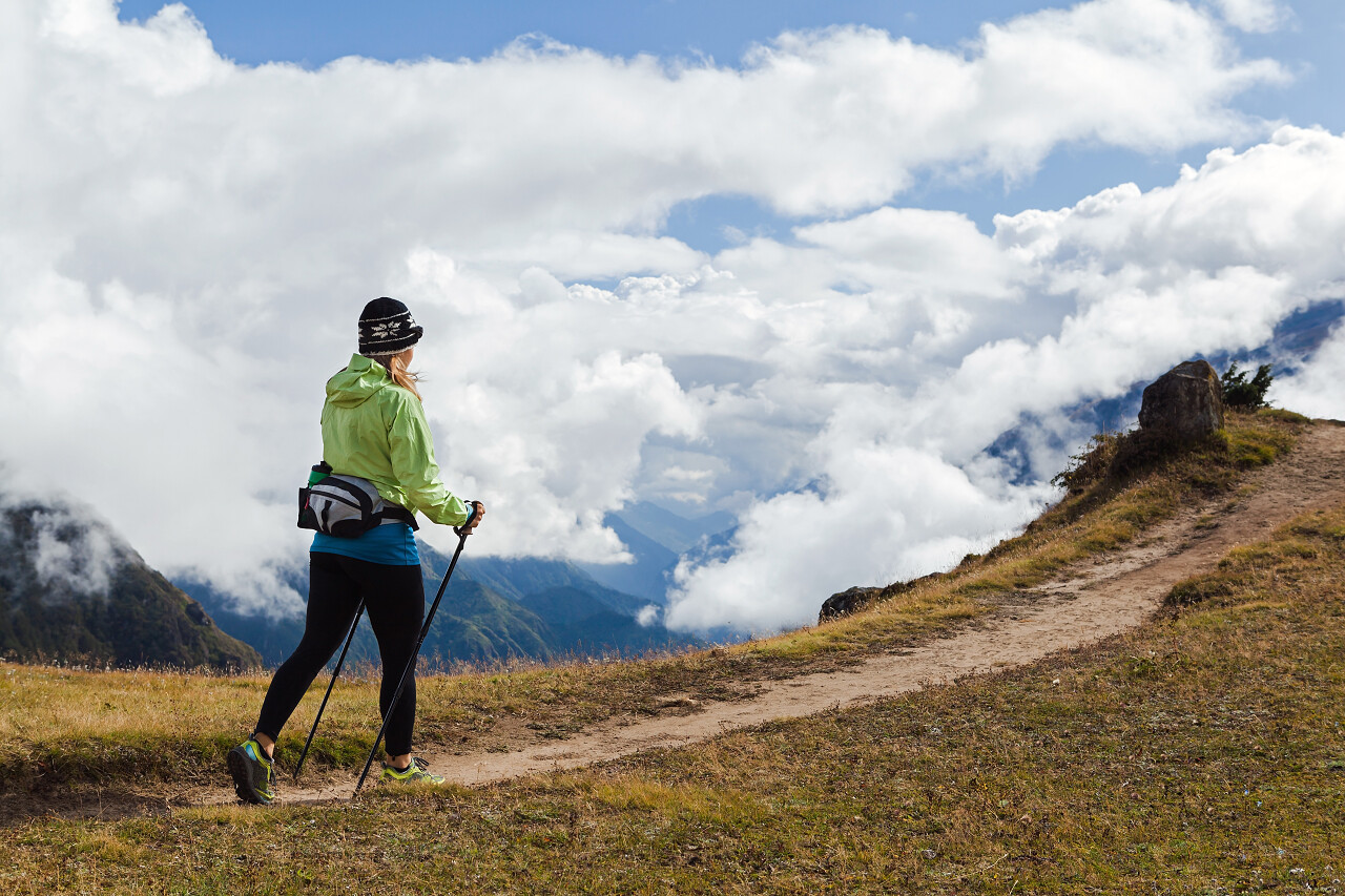 女人远足者秋季性质的美丽的山风景徒步旅行努力克服困难