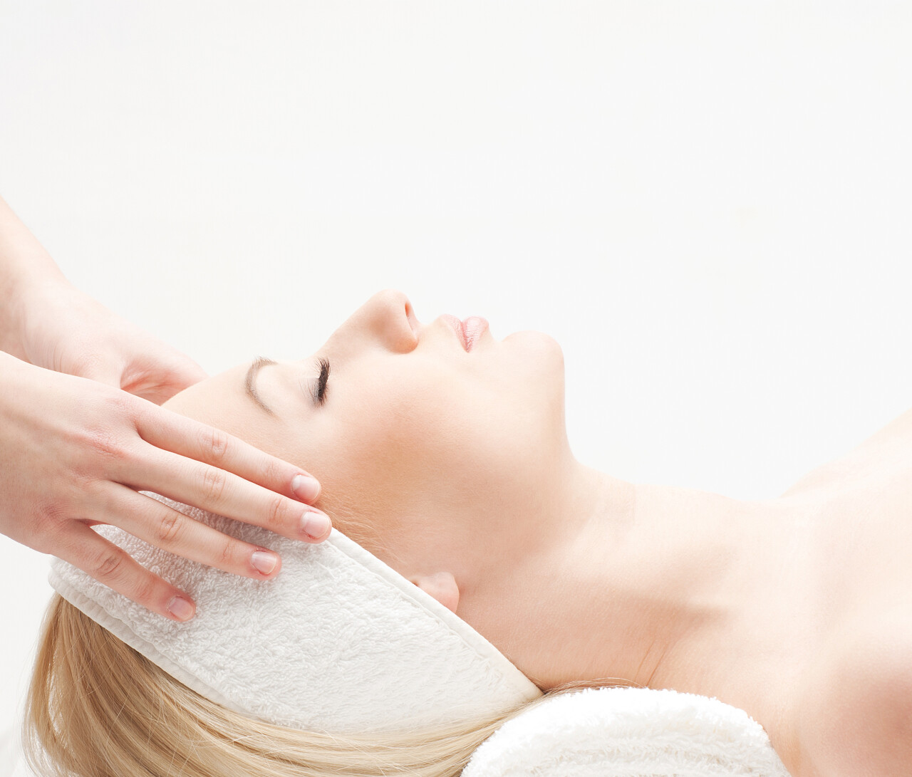 年轻漂亮的女士得到温泉治疗面部按摩中医养生头部按摩