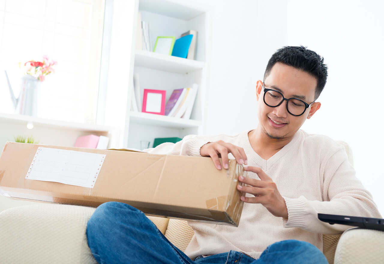 男性收到快递包裹在家里打开它