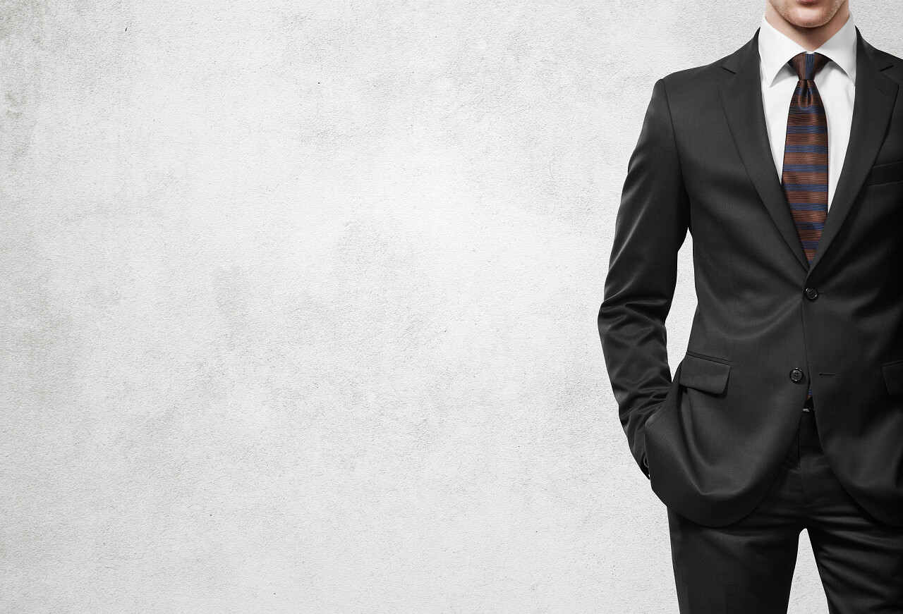 轻质混凝土墙背景上西装的男人