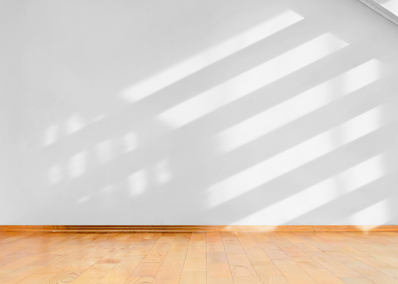 空房间木地板和白墙上的对角阴影