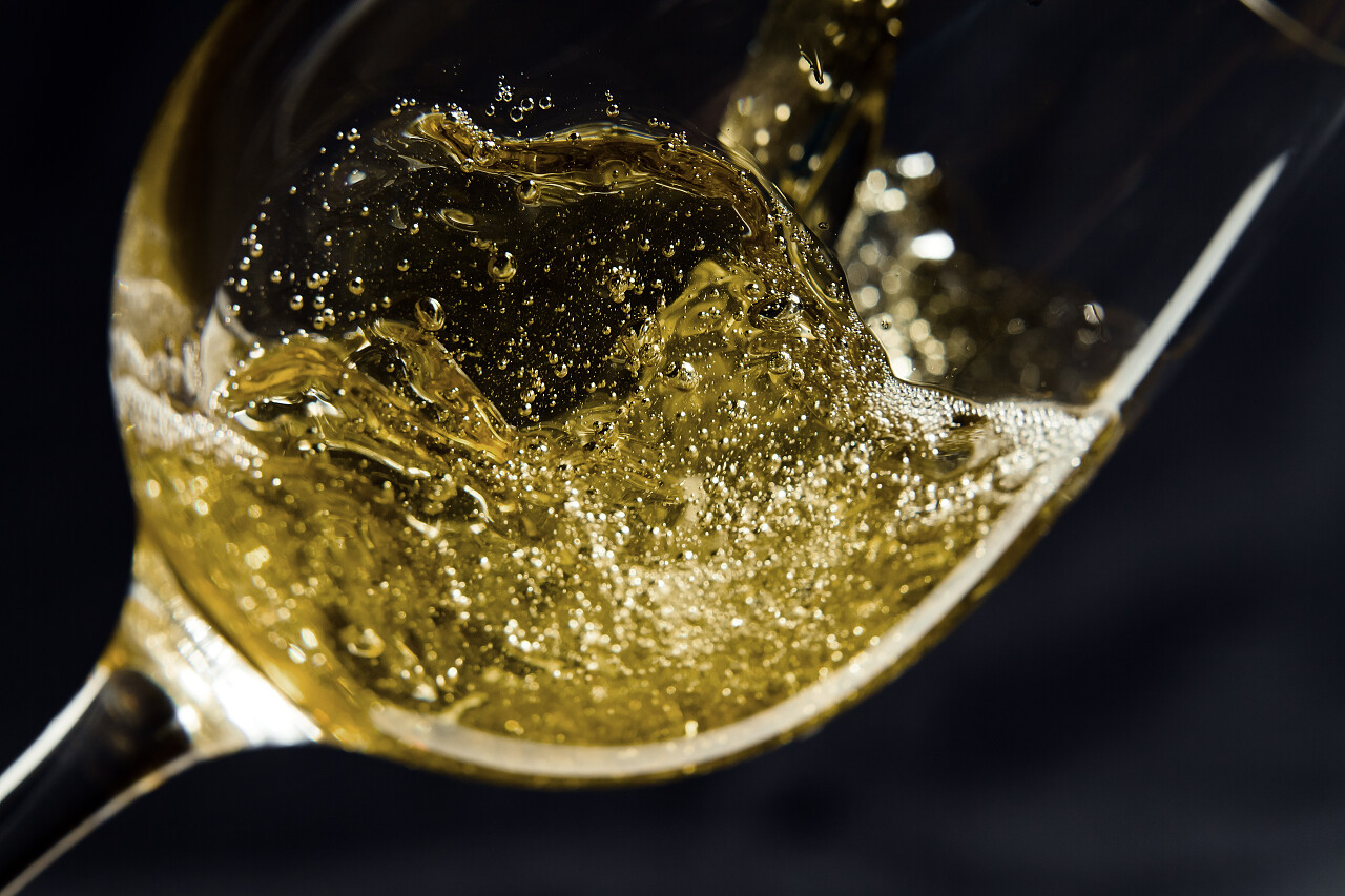 白葡萄酒被注入到一个玻璃酒杯