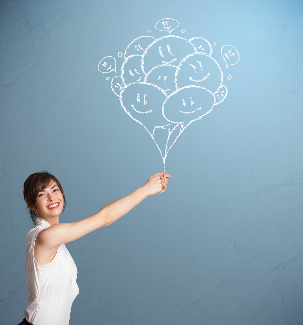 快乐的年轻女性与微笑气球绘图