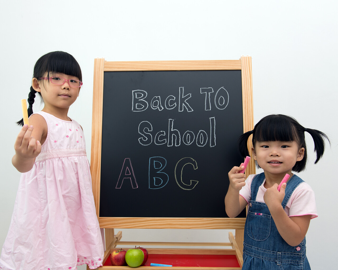 孩子们拿粉笔在黑板前站