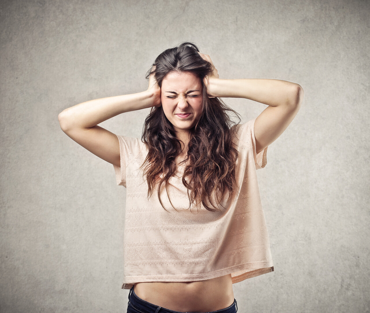 用她的双手覆盖住耳朵的女人焦虑暴躁