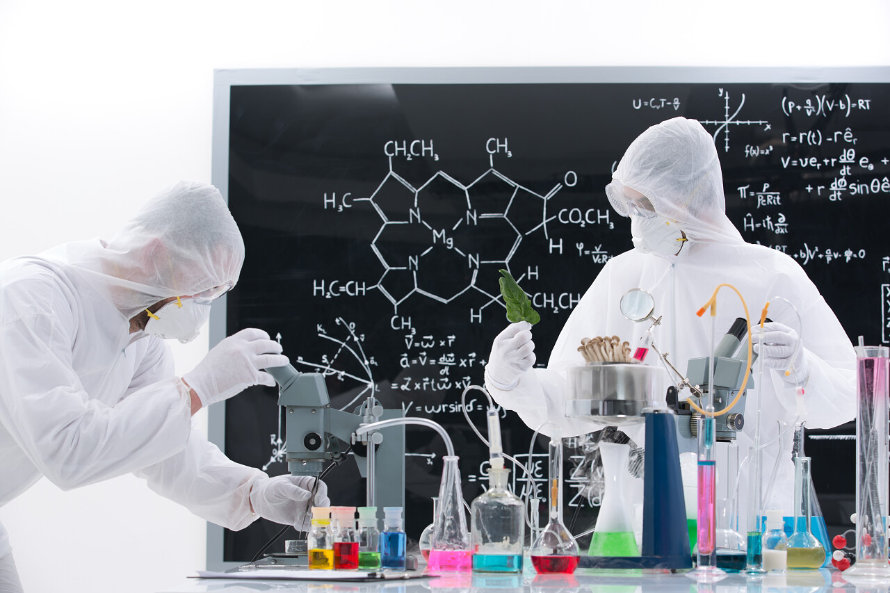 化学背景下的实验室两个人在用彩色试管做实验