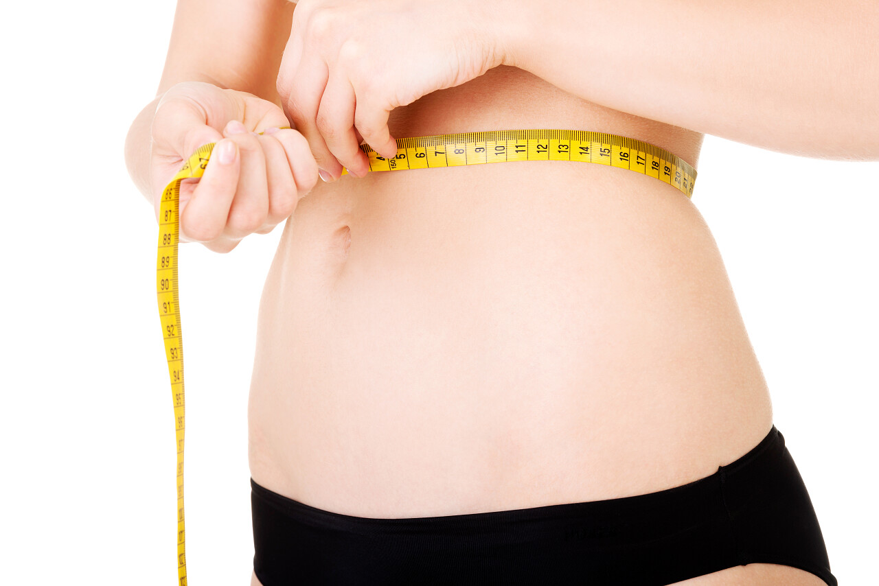 测量腰用磁带的年轻女子