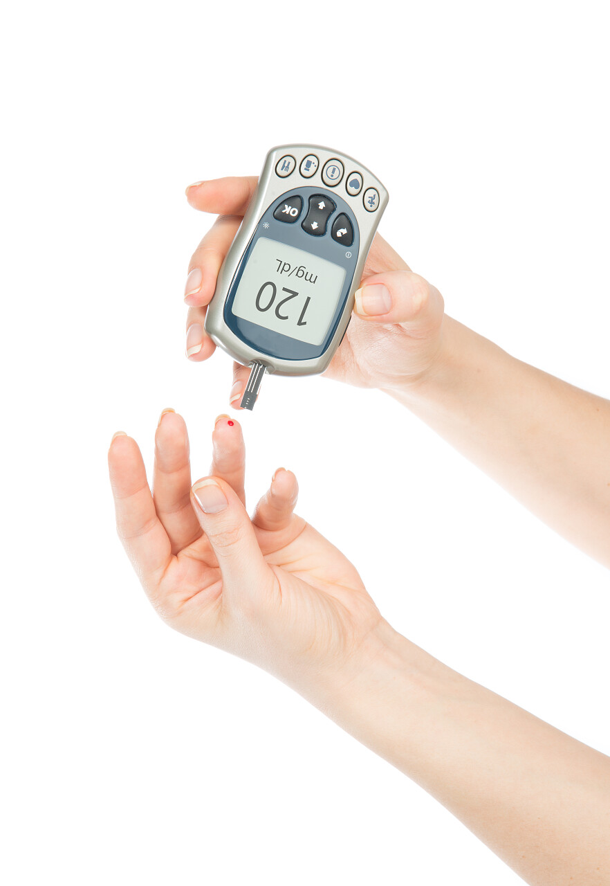 糖尿病病人测量血糖水平血液测试使用迷你血糖和小滴血从孤立在白色背景上的手指和测试条