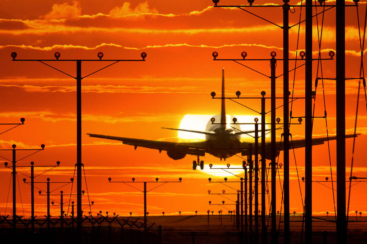 喷气式飞机离境机场跑道在落日的天空背景