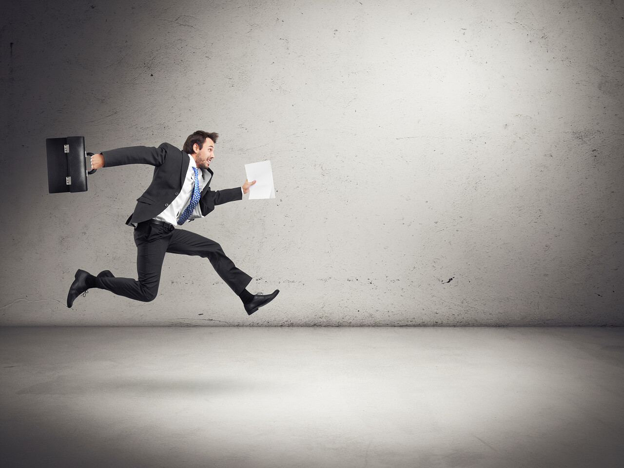 与过去的空墙上的公文包运行的商人业绩业绩上涨