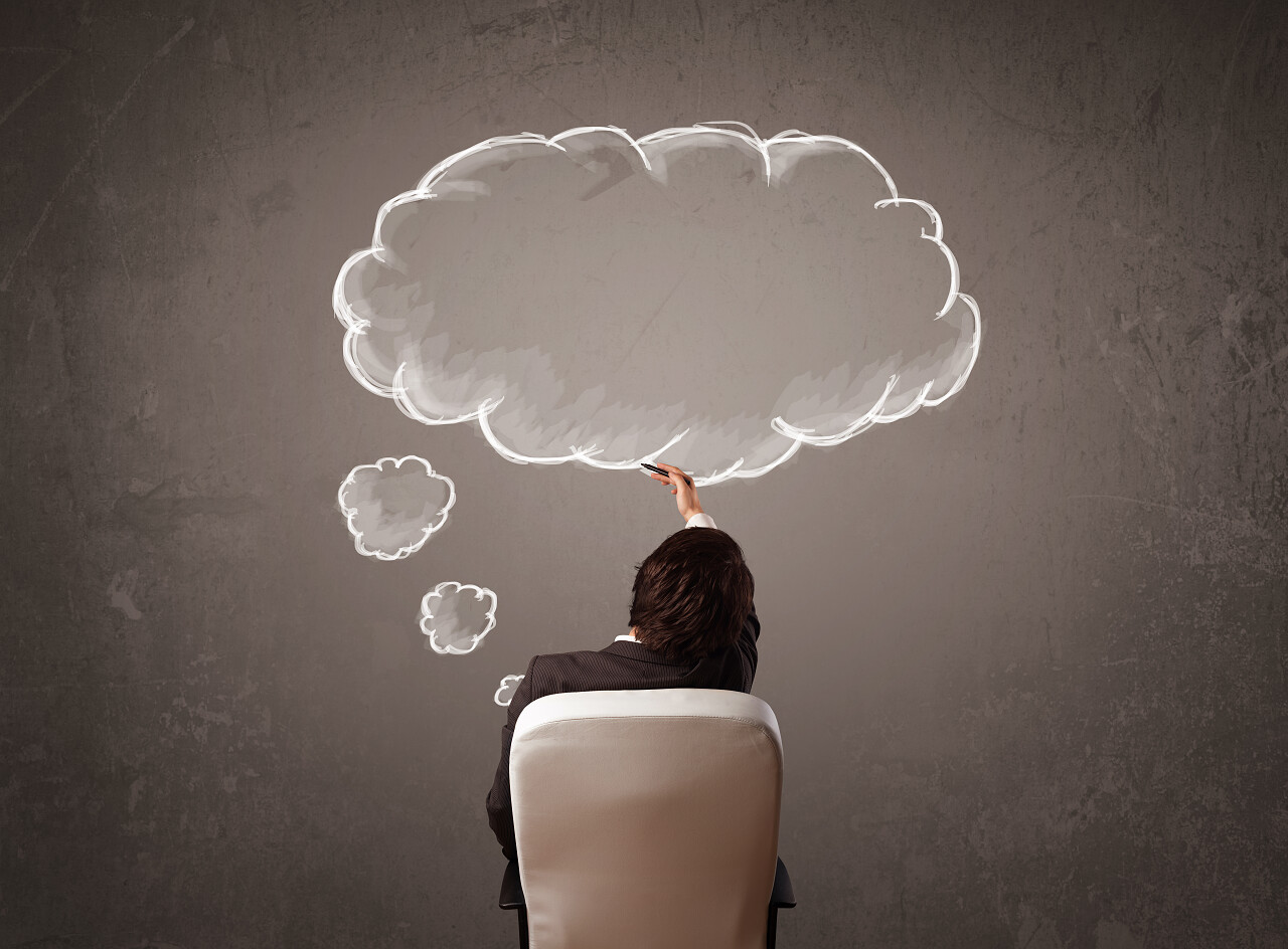 年轻的商人坐在办公室椅子上与云以为墙前他头顶的黑板上速写