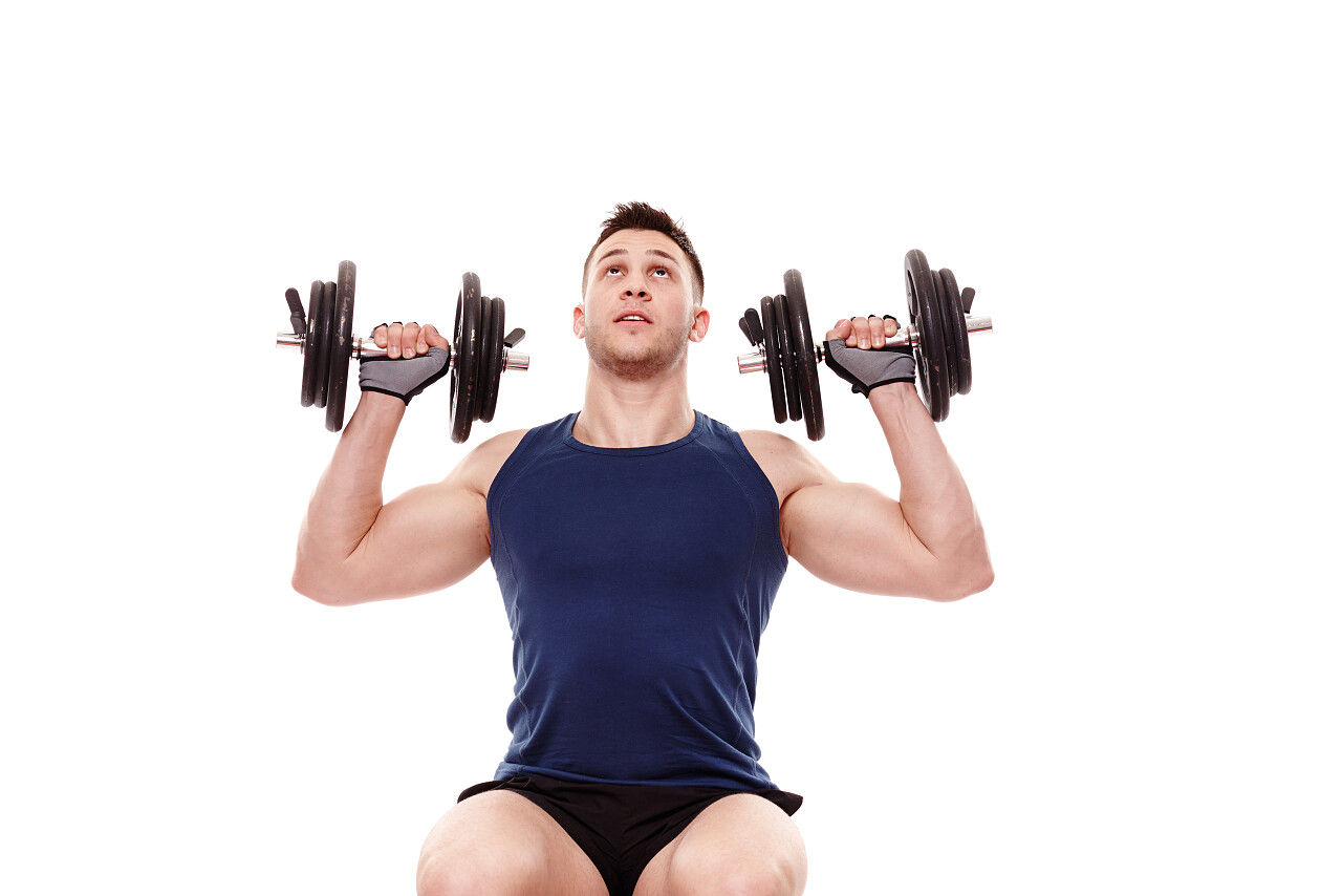 画室肖像英俊的年轻男子工作三角肌与重的哑铃孤立在白色的背景