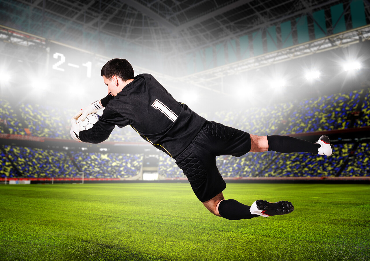 足球或橄榄球的门将在体育场上捕捉球