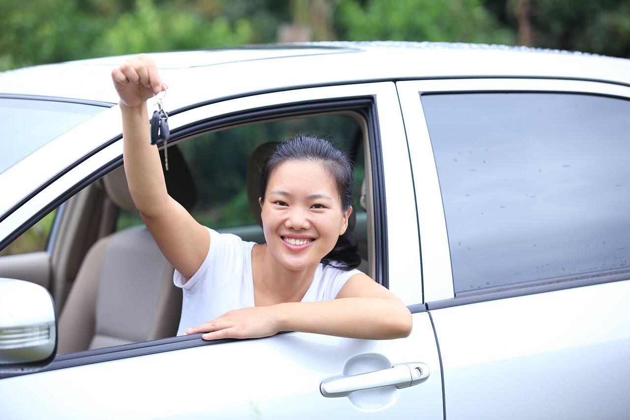 快乐的女司机拿着从那辆车的钥匙