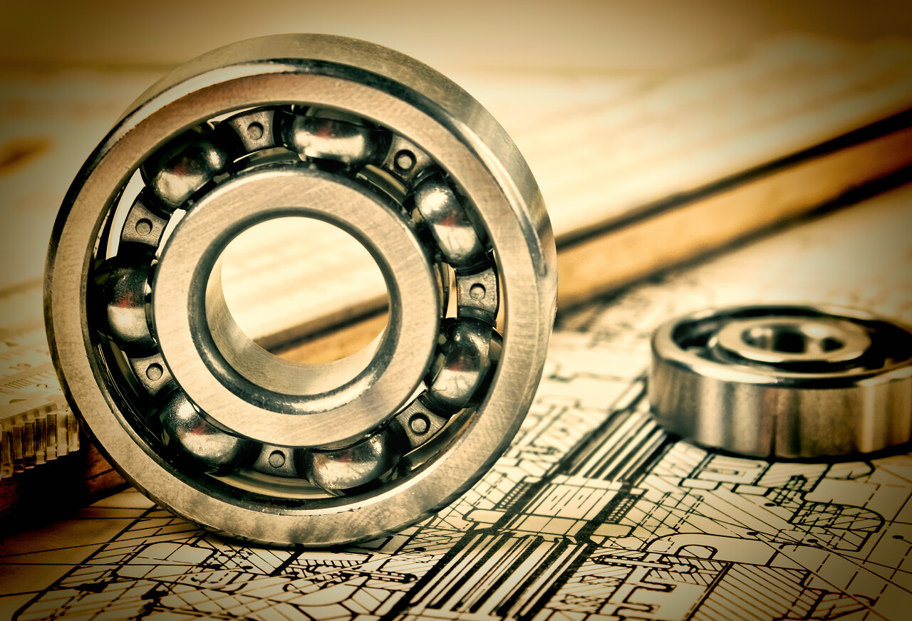 摆放在设计图上的两个机械轴承