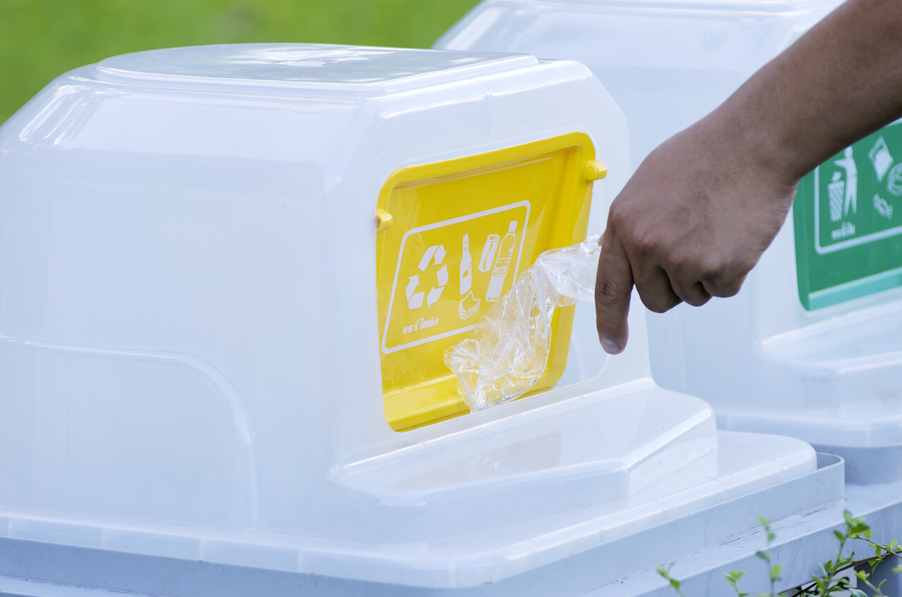 将垃圾丢入可回收垃圾箱的手