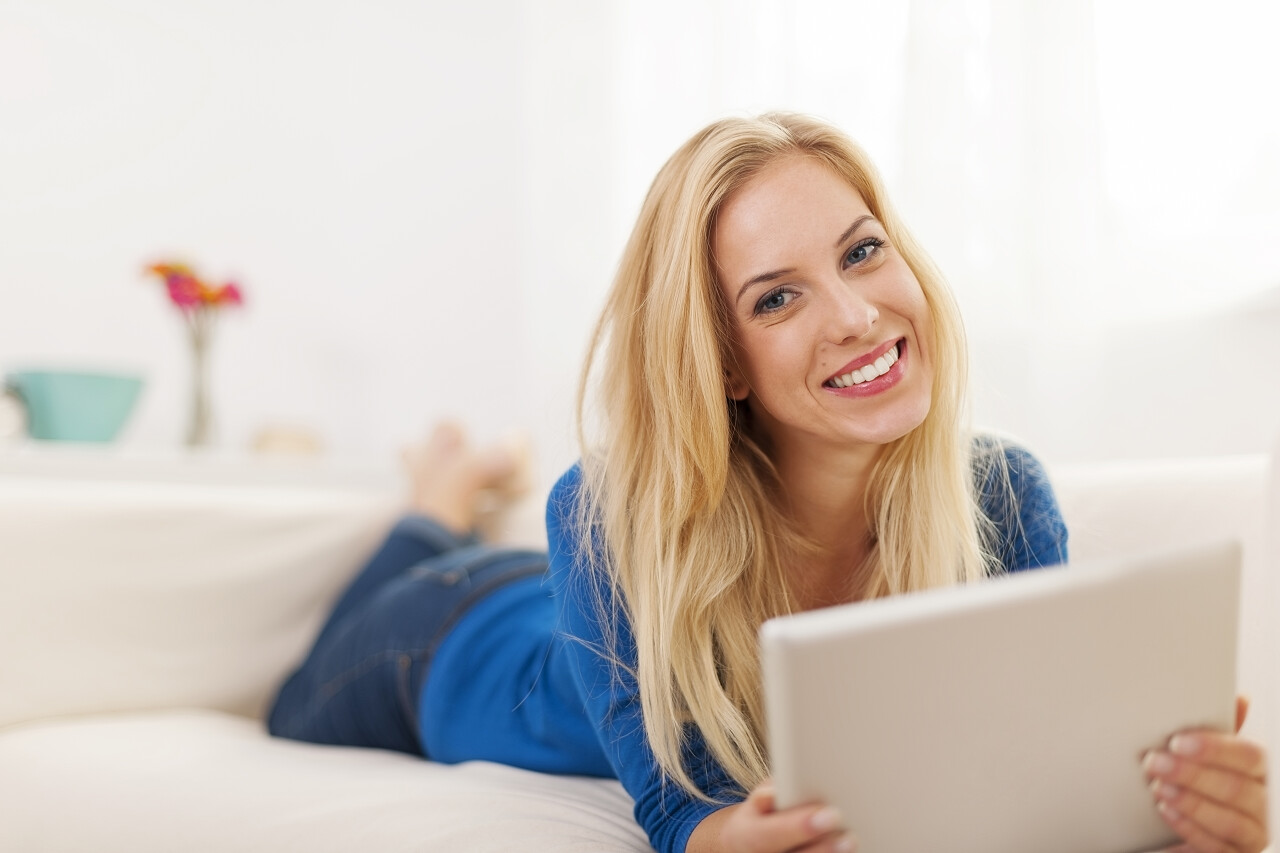 美丽的女人在家里用平板电脑