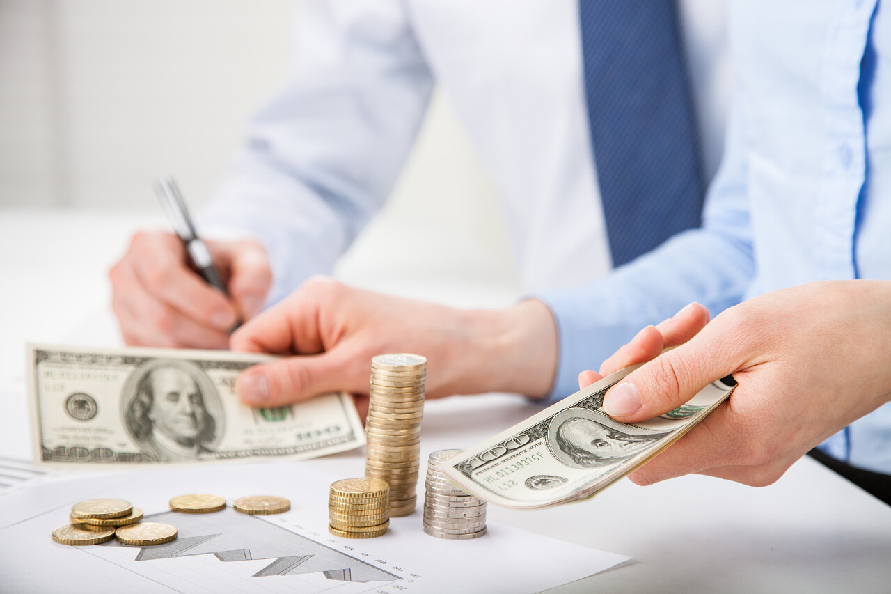 会计师计算利润 计数纸币和硬币和在纸上做笔记的手的特写镜头