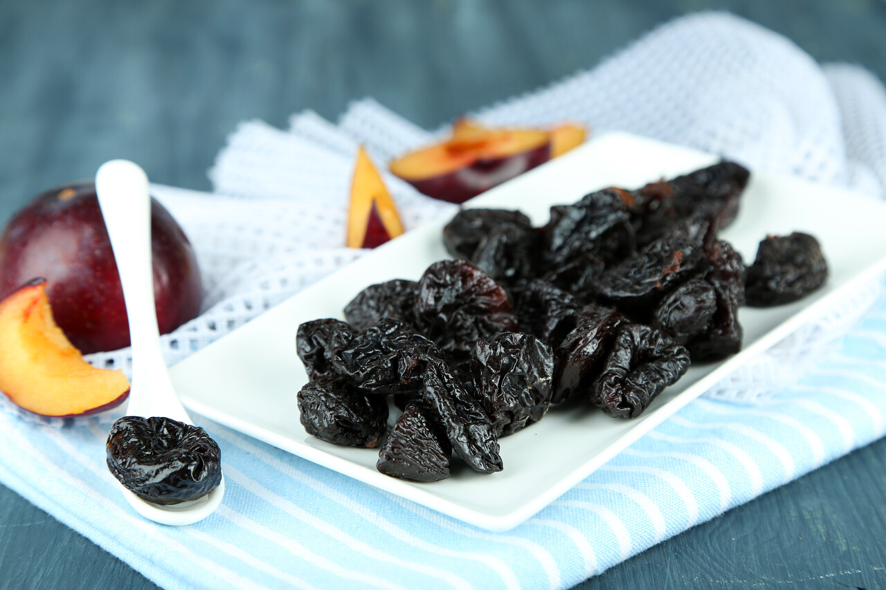 新鲜的和干的李子在餐巾纸上