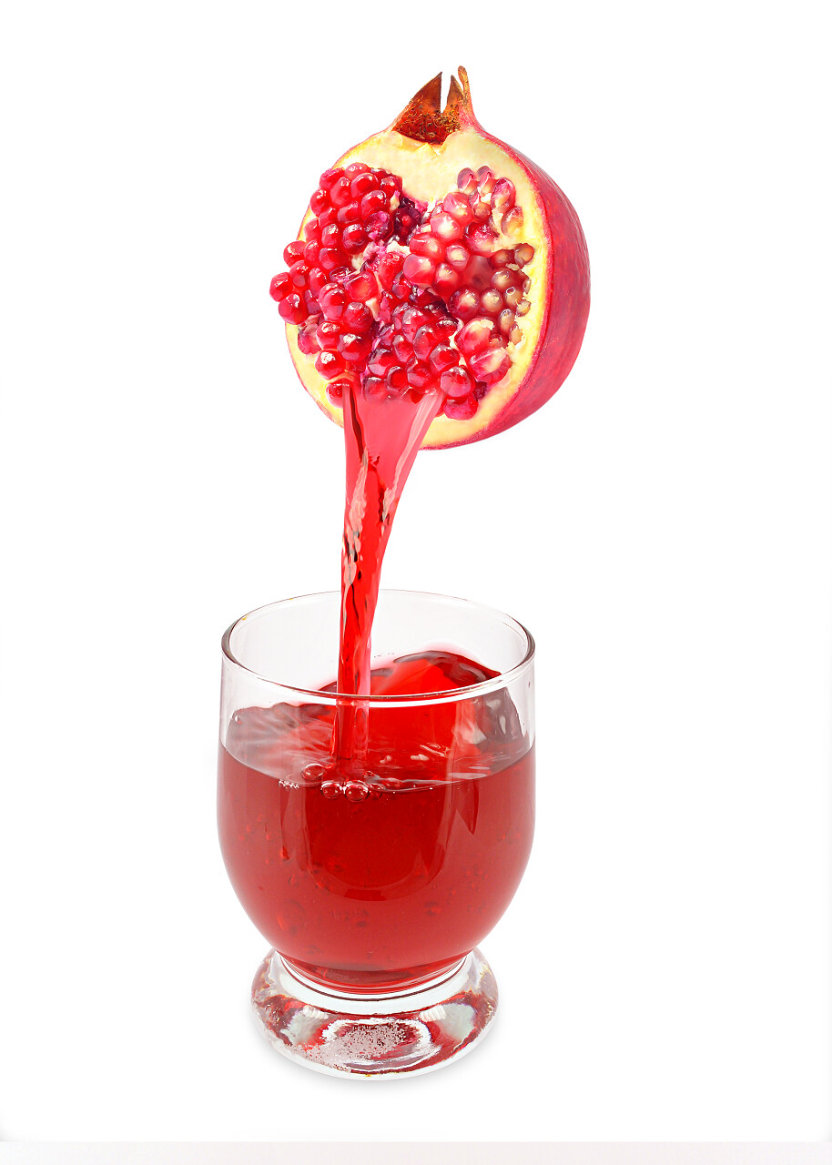 从石榴流入杯子的新鲜石榴汁