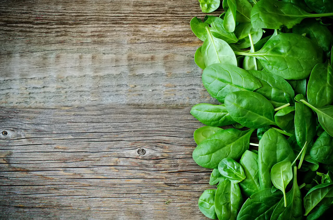 一堆放置在木板上的新鲜菠菜