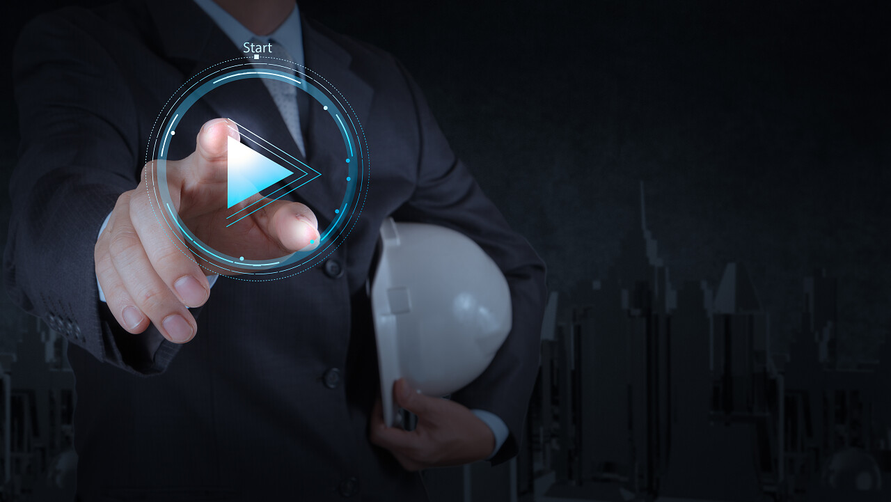 工程师的手按播放按钮标志启动