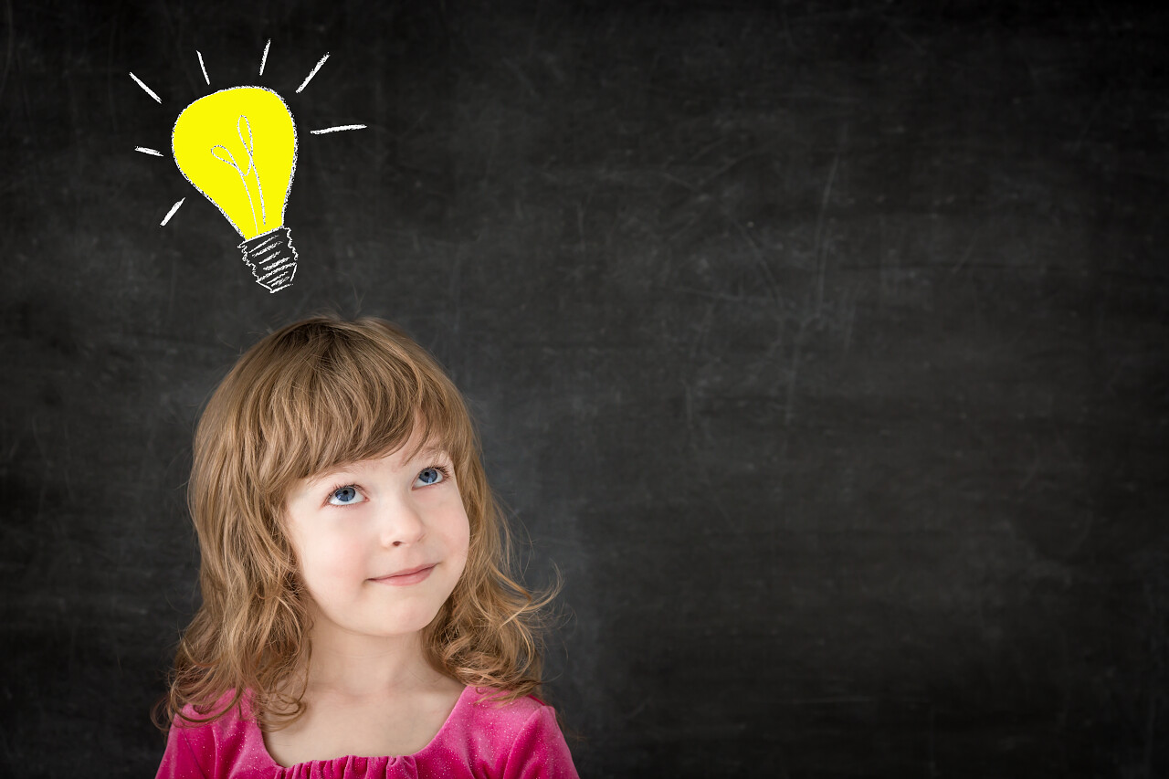 班级里的聪明孩子针对黑板上快乐的孩子绘图的灯泡思想理念思维思考微笑的小女孩