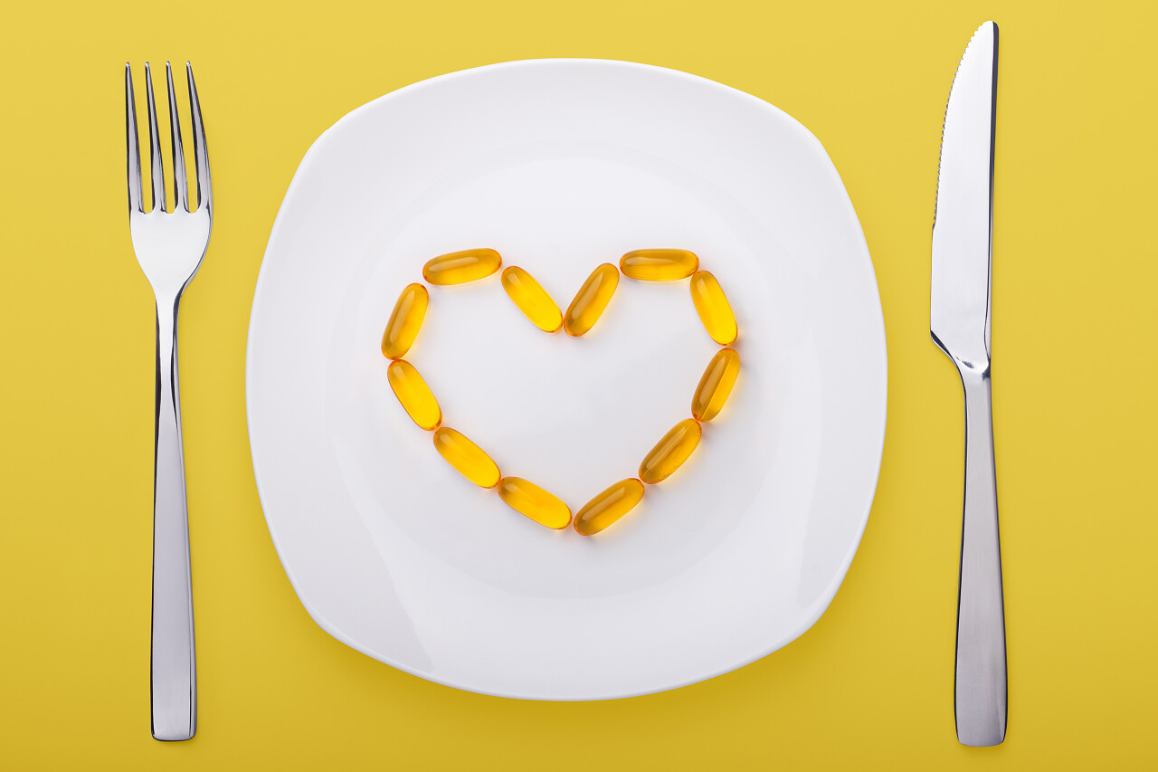 盘子上放着摆成心状的玉米粒 盘子左右两边放着叉子和刀具