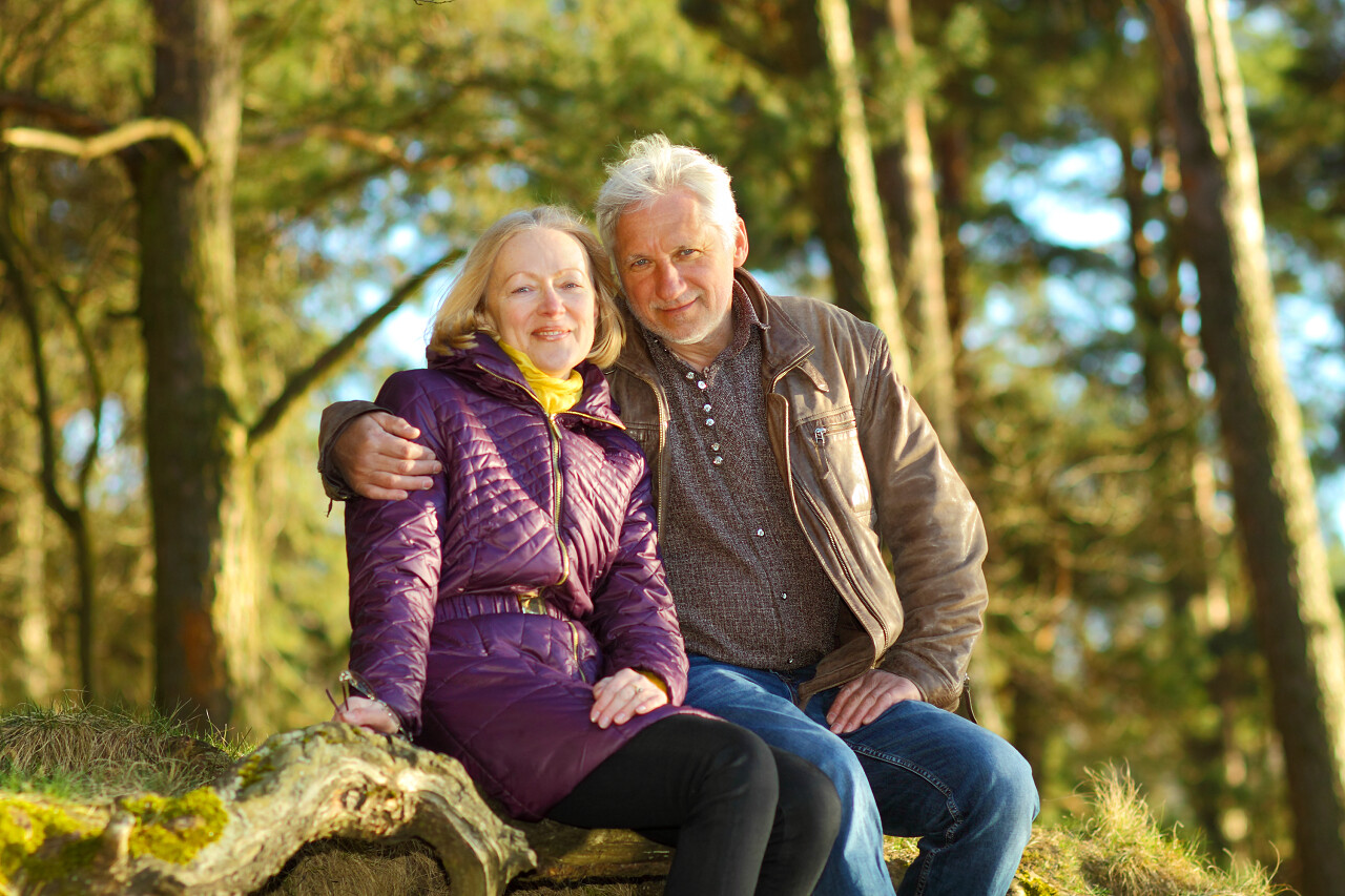老夫妇拥抱在一起看日落晚年幸福微笑的老人