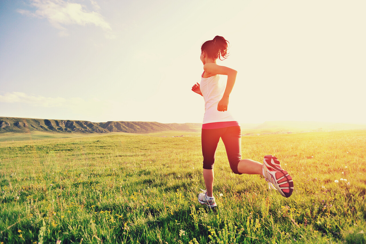 草海边上运行的跑步运动员女人健身日落运动励志