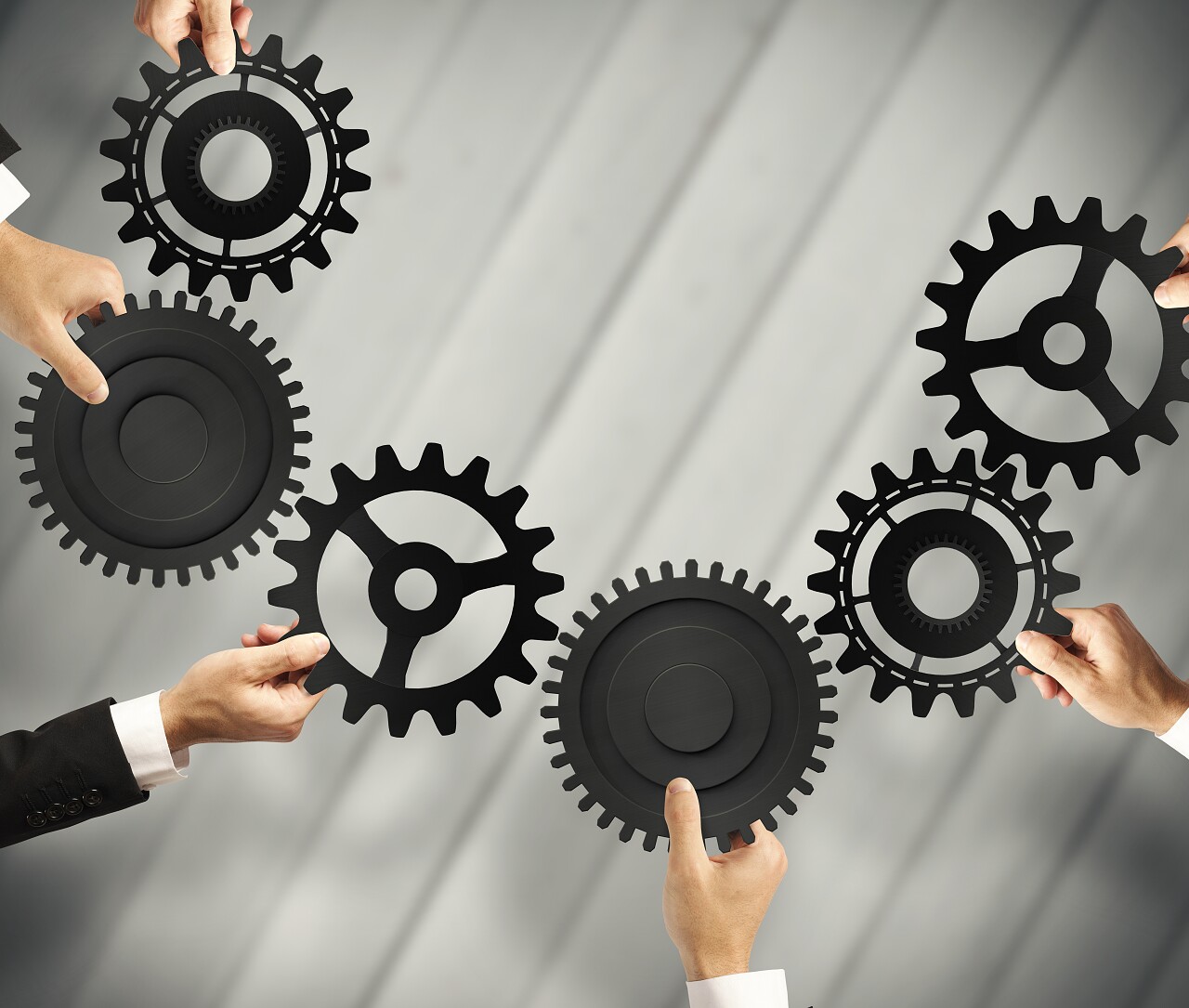 多个拿着齿轮连接的人团队协作团队合作