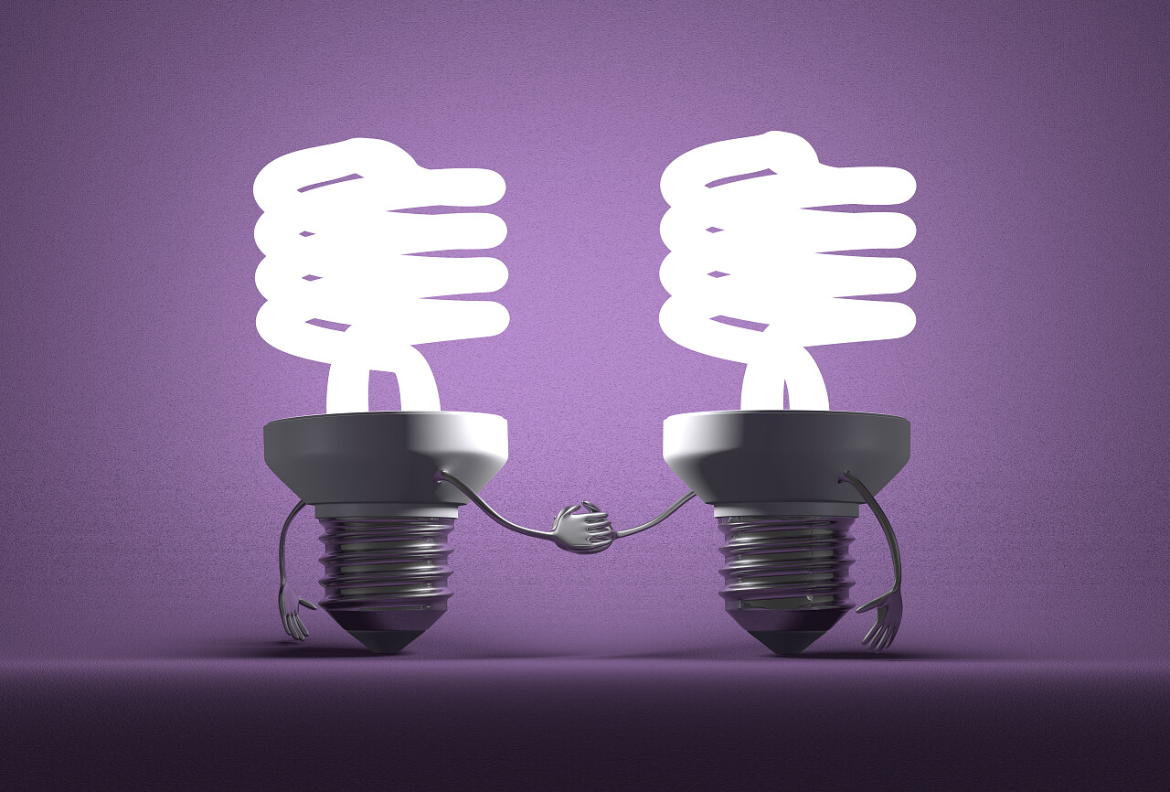 紫色渐变阴暗背景里两个握手的发光灯泡机器人