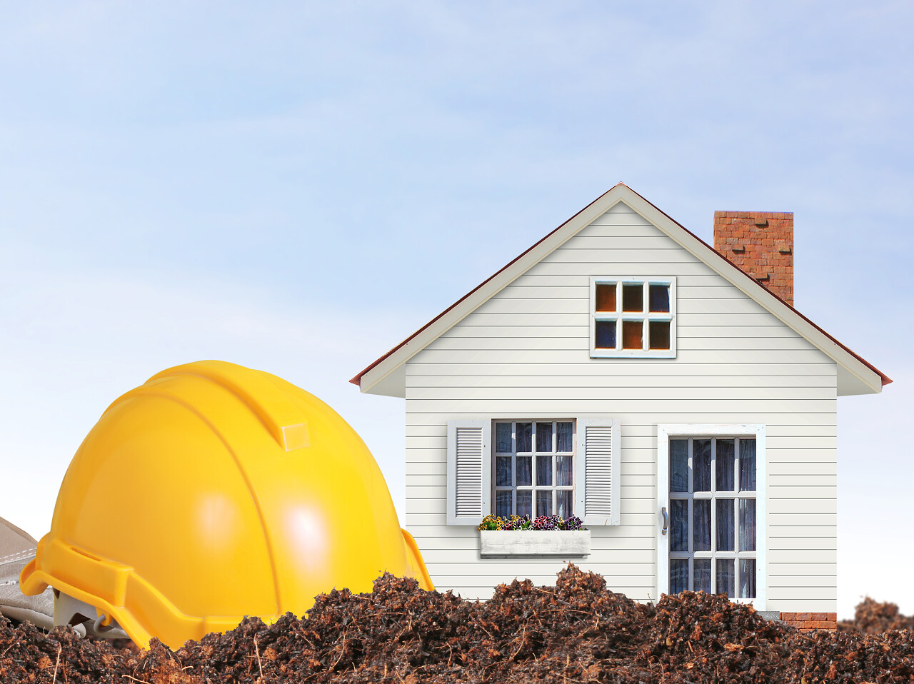 美丽房子外面一顶黄色显目的建筑工人安全帽