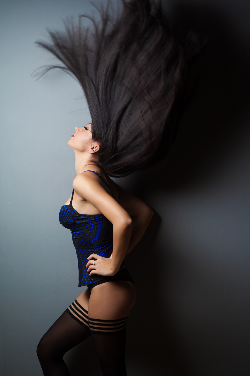 黑色渐变背景里一个长发飞扬的性感女性女生头发长头发美女