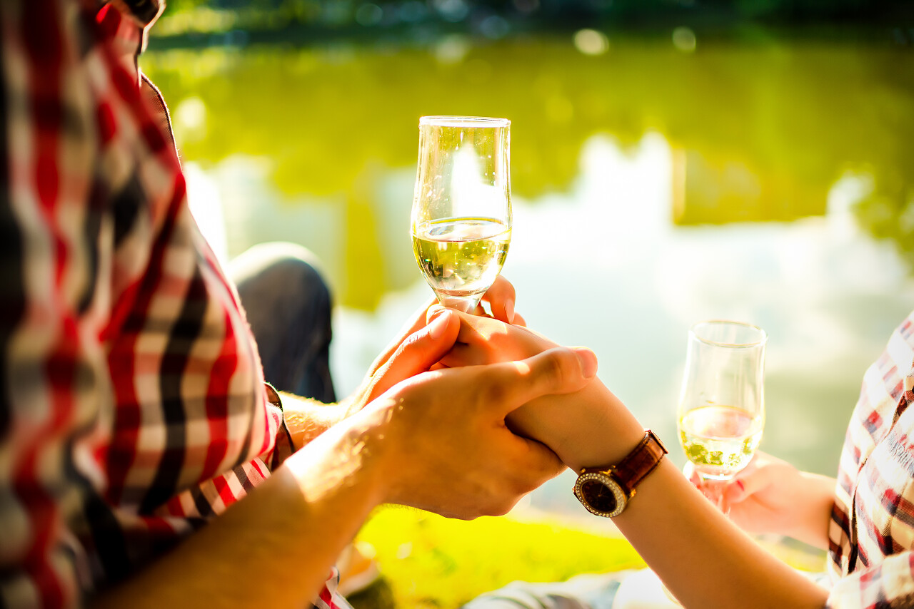 男人和女人在日落时戏剧性叮叮当当酒杯香槟水背景