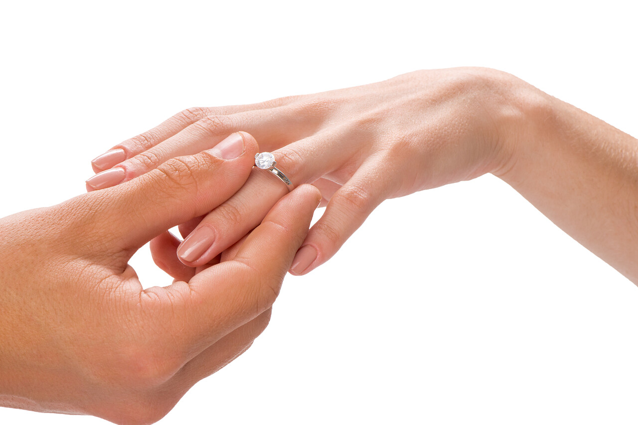 新郎和新娘交换戒指的特写镜头隔离在白色背景上