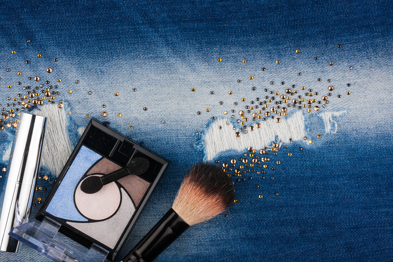 从化妆品的破旧的牛仔裤水钻与地方为您的文本与静物