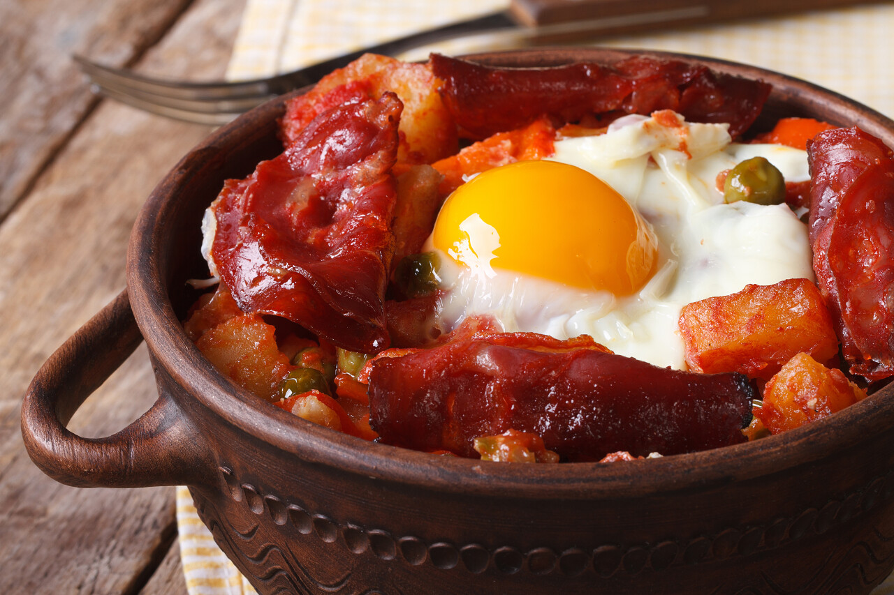 西班牙菜烤的鸡蛋香肠和蔬菜在锅中