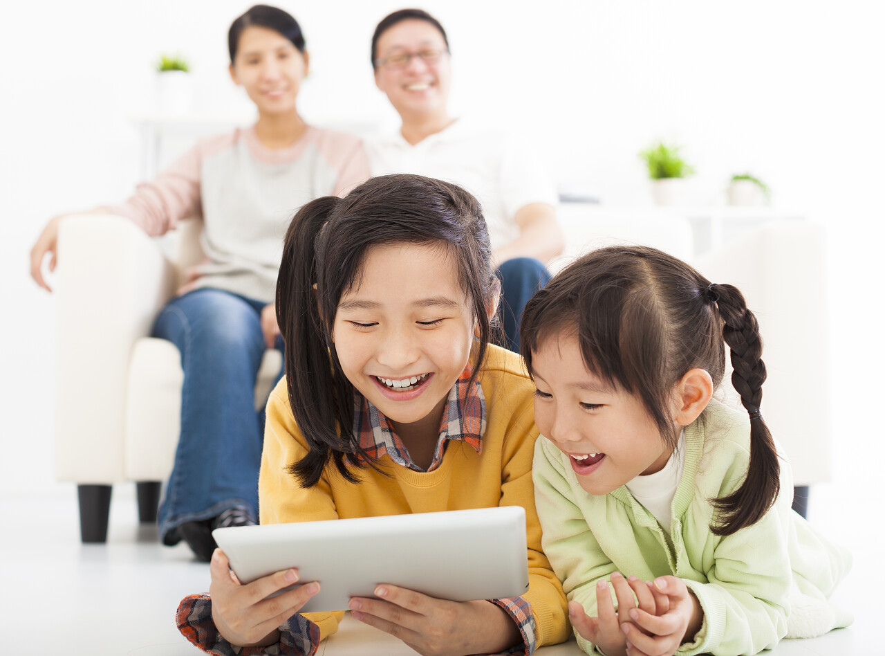 快乐的小女孩使用平板电脑微笑的小女孩