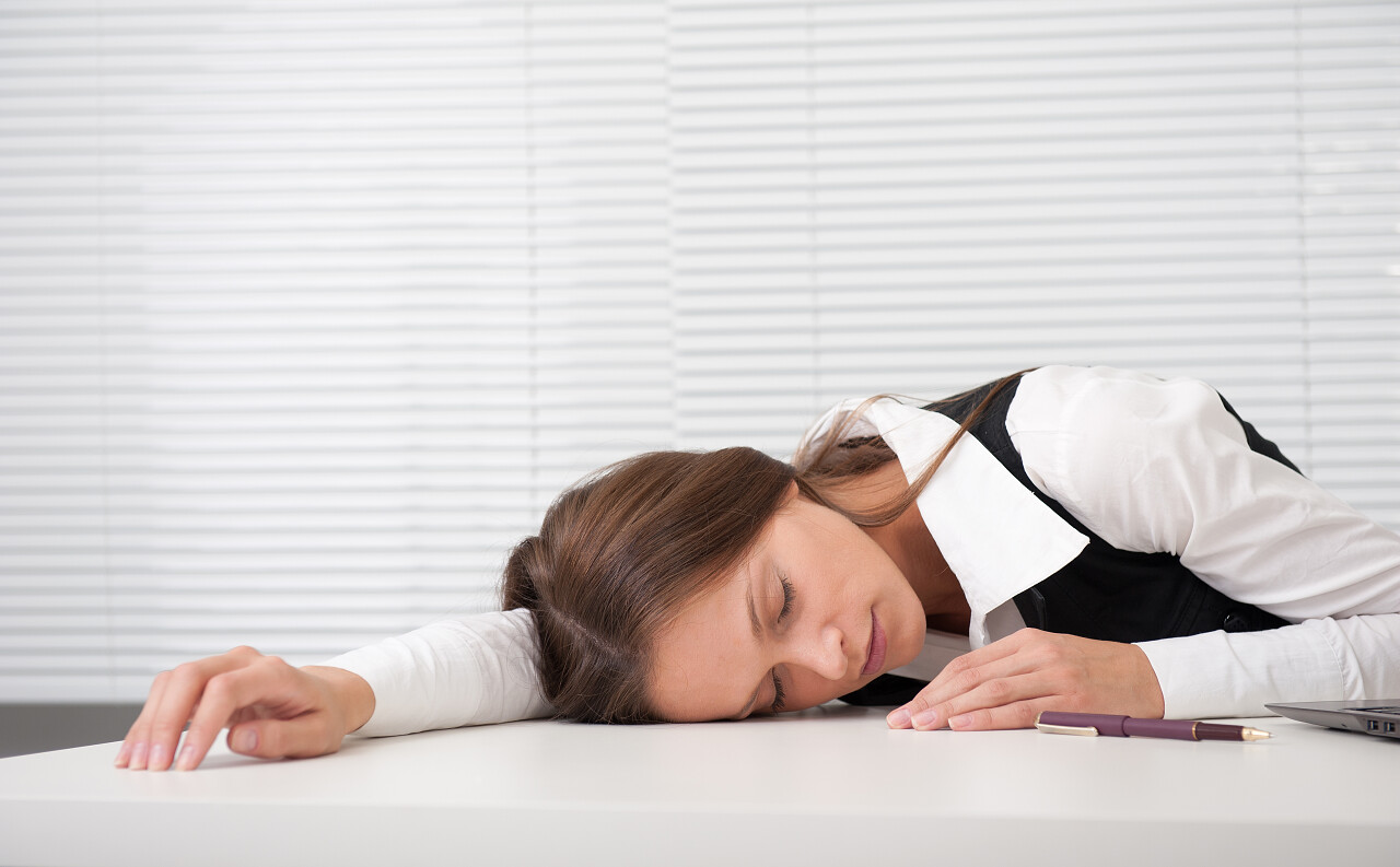 累了的秘书在工作场所睡觉的女商人