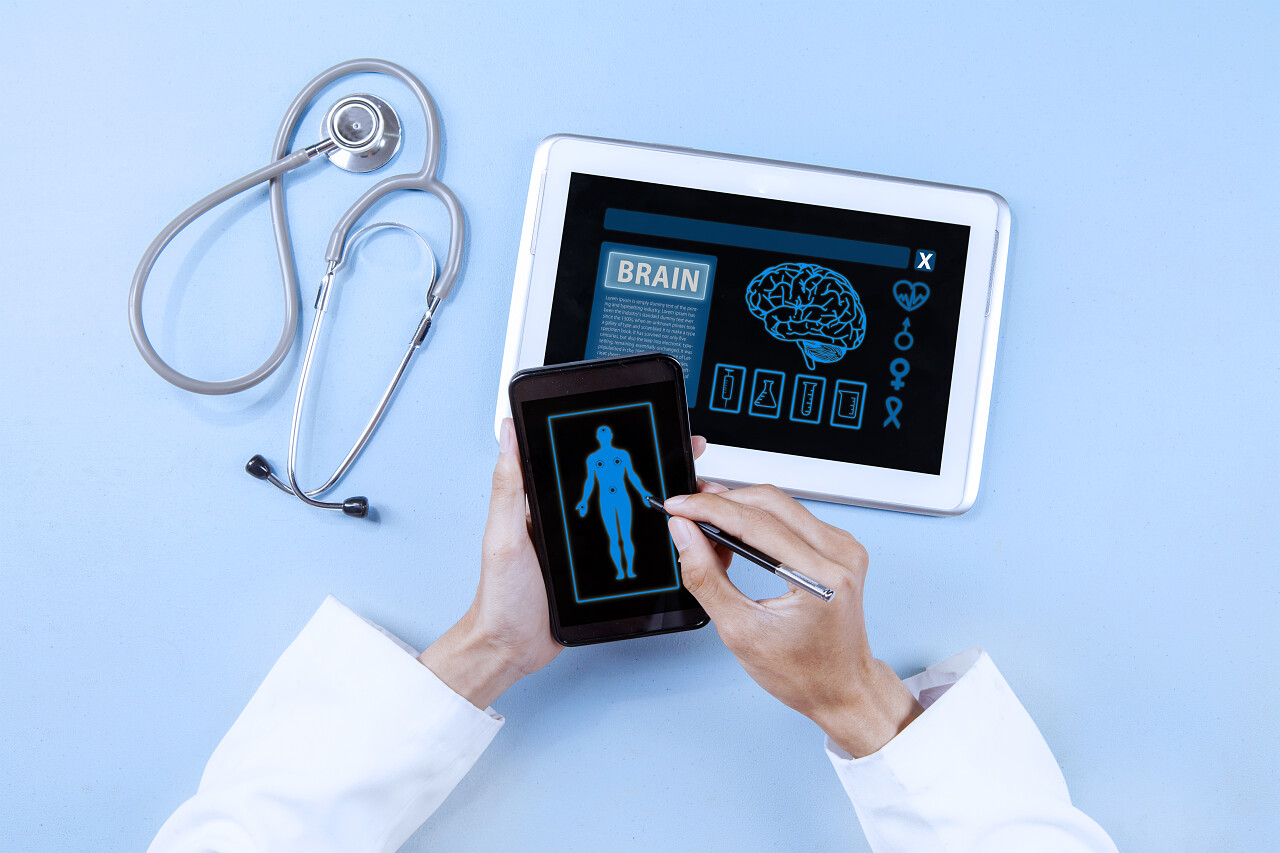 使用智能手机和数字平板电脑进行诊断的医生手的特写