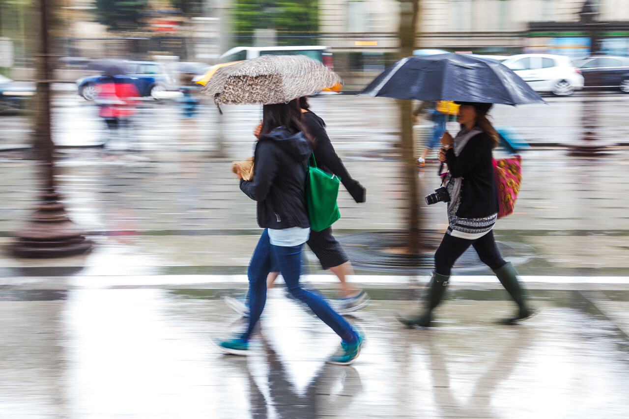 年轻人走在下雨的城市