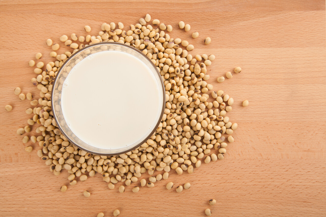 豆浆和大豆放在木桌上的杯子里