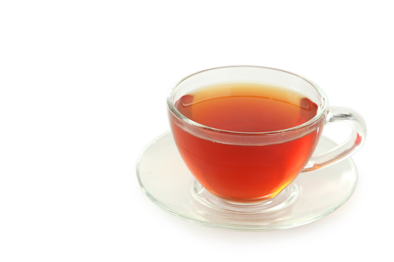 白色背景杯碟上的红茶