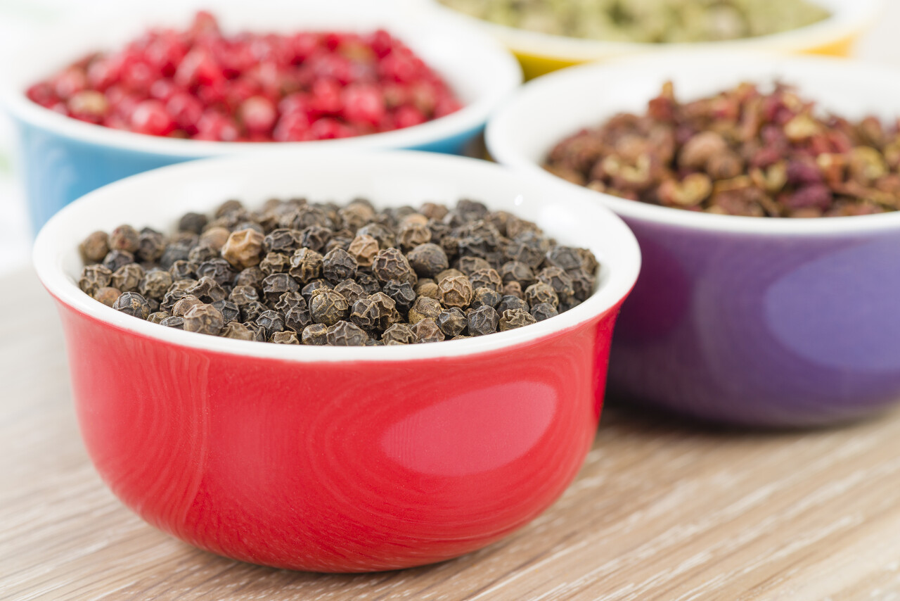 粉红色和绿色干辣椒在五颜六色的碗