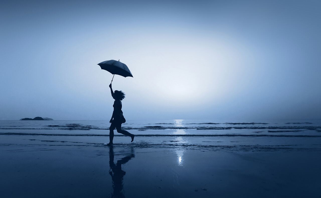 小女孩在海边海滩打伞