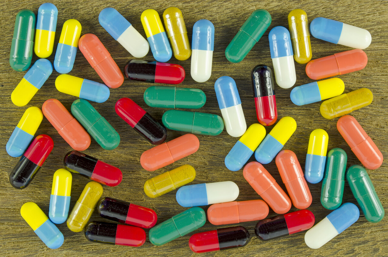 多彩的口服药物在明胶硬胶囊对老式木背景.