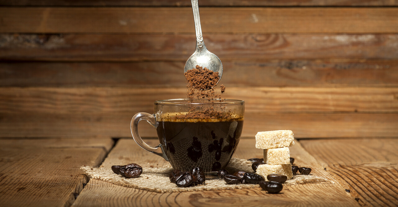 玻璃咖啡杯子和勺子速溶颗粒咖啡老木背景.