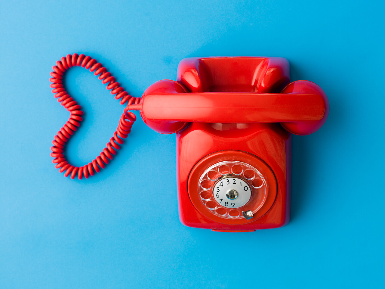 红色手机的上视图与心脏形状由其电缆